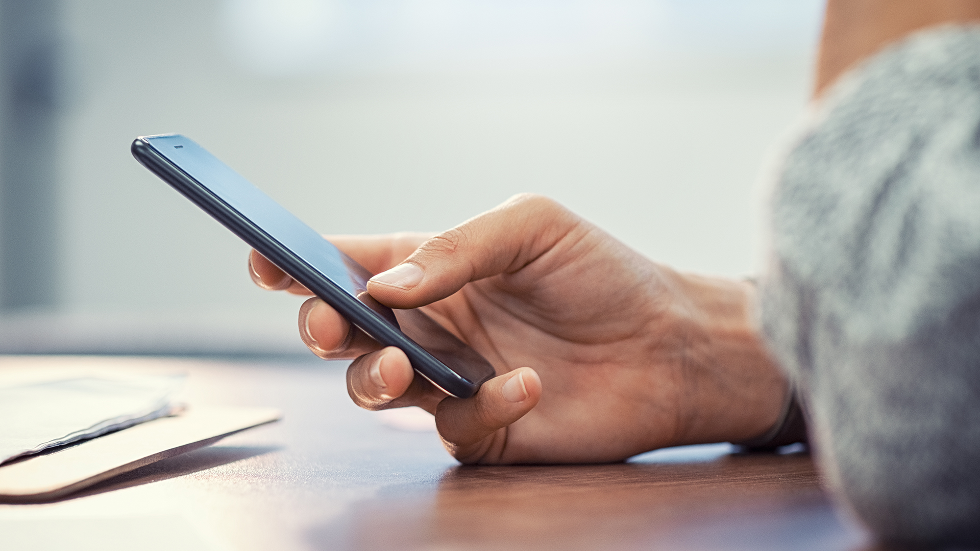 Banner of hand holding a smart phone.