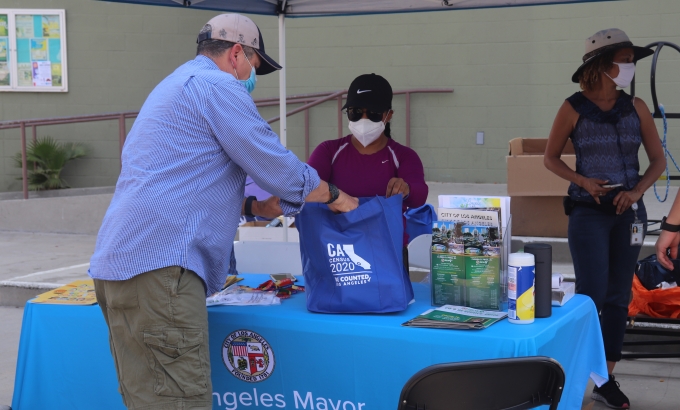 Guest receiving a goody bag at an outreach event.