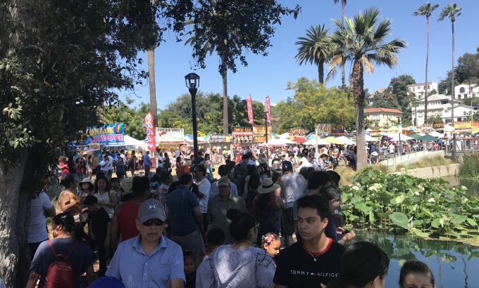 Group of people walking at an outdoor festival.